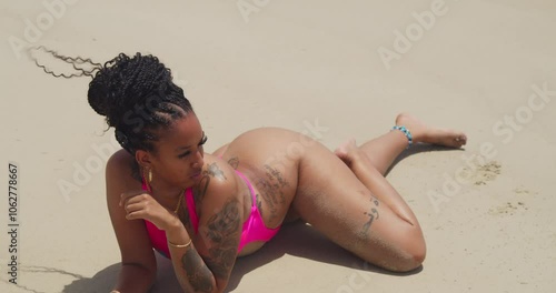 A girl in a pink bikini makes the most of her day at the picturesque Las Cuevas Beach in Trinidad. photo