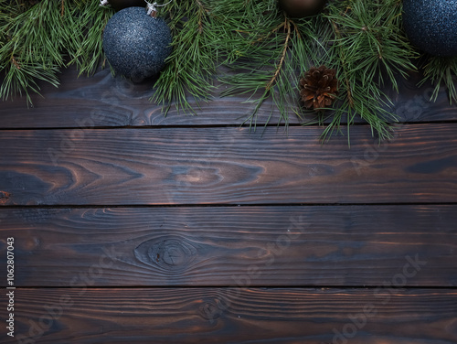 Festive Christmas wooden background with copy space, fir tree branches and blue Xmas baubles. New year celebration, winter holiday concept. Top view of flat lay