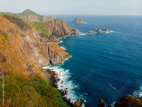 Aerial drone view of cliff hill by the blue sea scenery at Orong Bukal in Buwun Mas, Lombok, Indonesia. photo