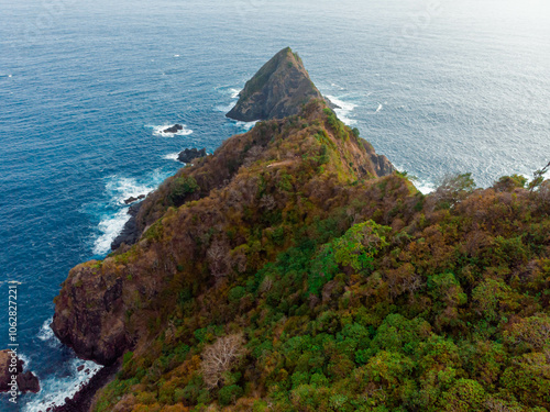 Aerial drone view of cliff hill by the blue sea scenery at Orong Bukal in Buwun Mas, Lombok, Indonesia.