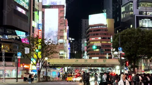 Busy night scene of Shibuya Station area with crowds and bright neon lights in Tokyo's entertainment district