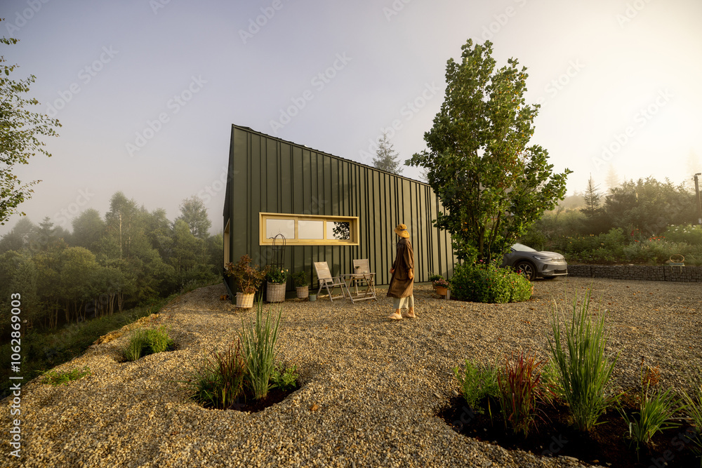 A person enjoys the peaceful morning light outside a modern cabin, capturing the essence of tranquility and solitude in nature A person enjoys the peaceful morning light outside a modern cabin, capturing the essence of tranquility and solitude in nature