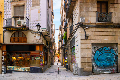 Looking down from Baixada de la Llibreteria street on the long narrow Carrer de la Dagueria full of shops and cafes in the historic Gothic Quarter of Barcelona, Spain. photo