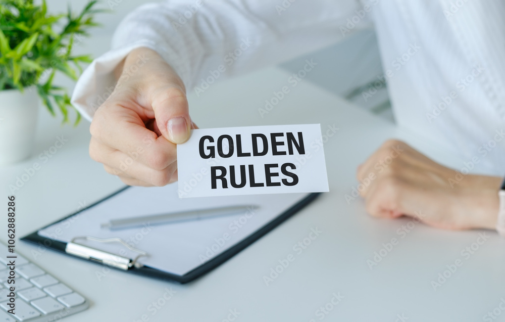 A person is holding a piece of paper that says Golden Rules A person is holding a piece of paper that says Golden Rules