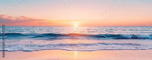 Beautiful sunset over the ocean with waves gently lapping at the shore.