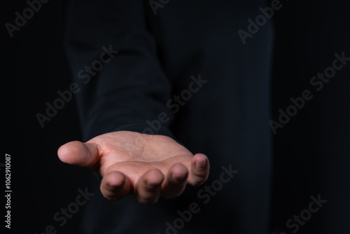 Open hand gesture against dark background, concept of giving or receiving.