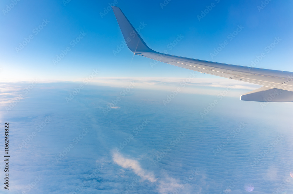 View from the airplane window at a beautiful cloudy sky and the airplane wing View from the airplane window at a beautiful cloudy sky and the airplane wing