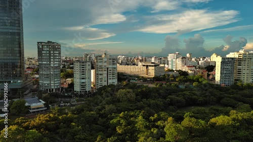 Anacaona 27 tower skyscraper and Enriquillo Lake, Santo Domingo cityscape in Dominican Republic. Aerial sideways photo