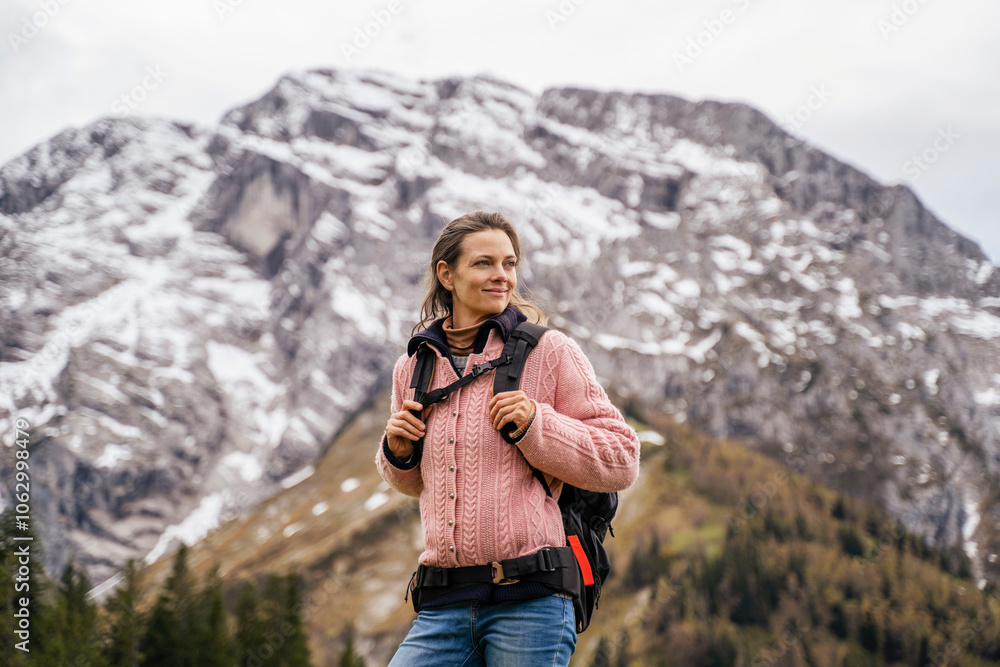 Smiling mature woman standing with backpack in front of Hinteres Freieck mountains at Berchtesgaden, Germany Smiling mature woman standing with backpack in front of Hinteres Freieck mountains at Berchtesgaden, Germany