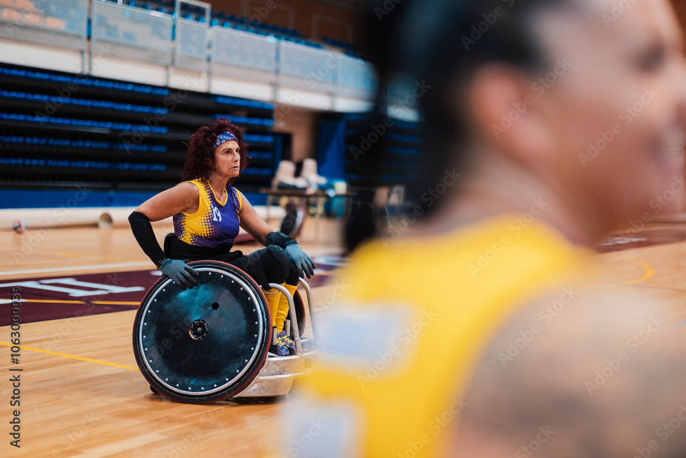 Disabled rugby player sitting in wheelchair and playing at sports court Disabled rugby player sitting in wheelchair and playing at sports court