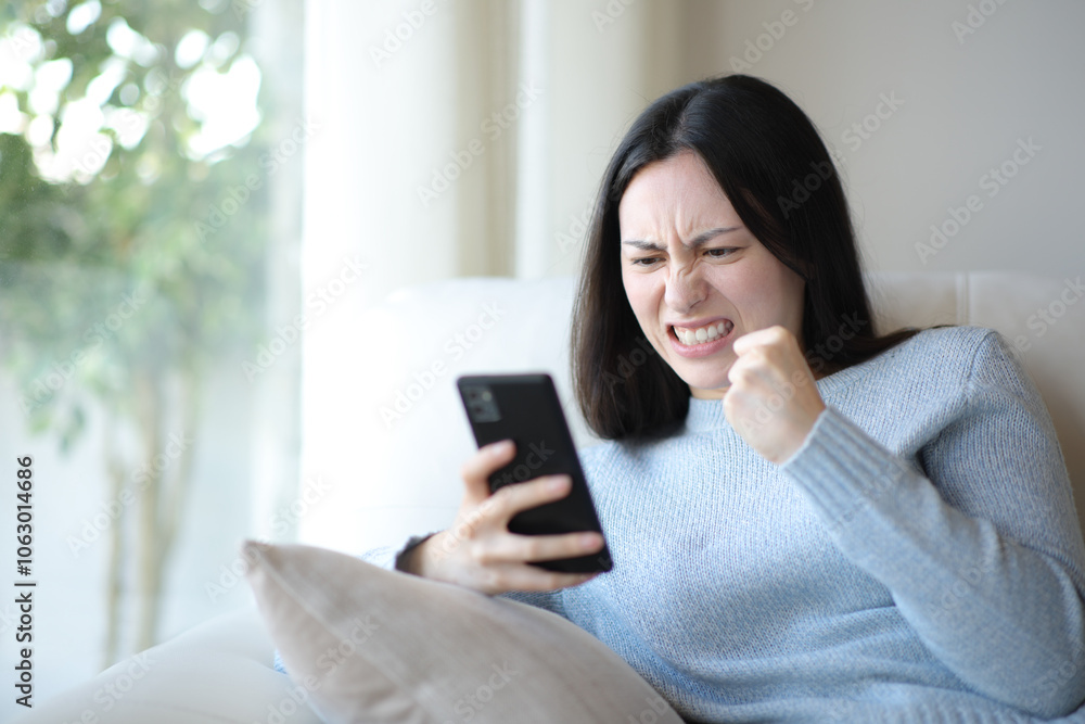 Angry asian woman checking phone at home Angry asian woman checking phone at home