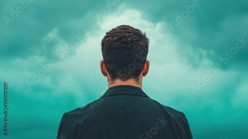 A cloudy sky with a single ray of light shining on a person, symbolizing the resilience and support needed for depression recovery