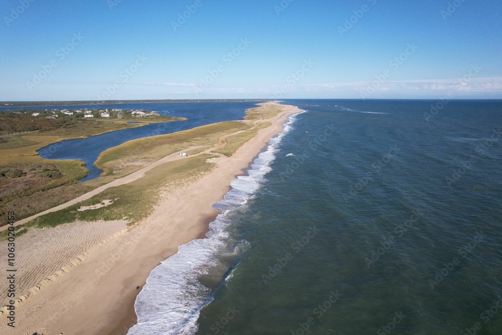 Aerial view of a stunning beach coastline with waves and clear blue sky. Aerial view of a stunning beach coastline with waves and clear blue sky.