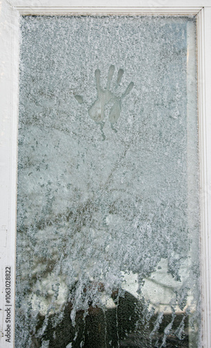 A handprint on a frozen window.