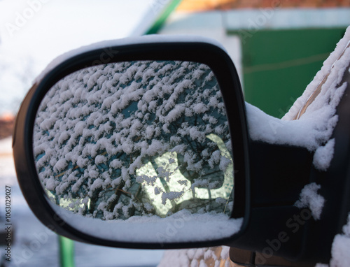 Rearview mirror of a car in the snow. Close up