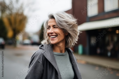 Portrait of a happy senior woman walking in the street and laughing