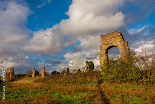 Ancient roman aqueduct beautiful arches ruins in Rome public park at sunset with beautiful clouds