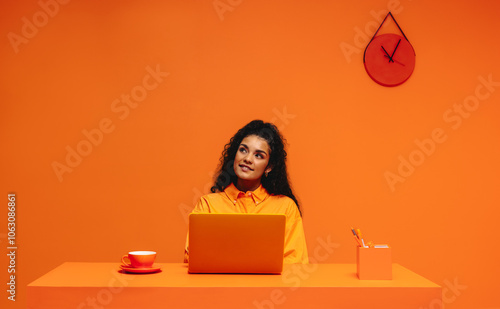 Pensive freelancer working in a vibrant, monochromatic office setting emphasizing creativity and focus photo