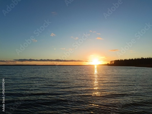 Red and yellow colored sunset over Rekyva lake. Sun set over lake. Some clouds are hangin in the sky. Blue yellow and red colored sky. Horizon over water. Saulelydis. Rekyvos ezeras. photo