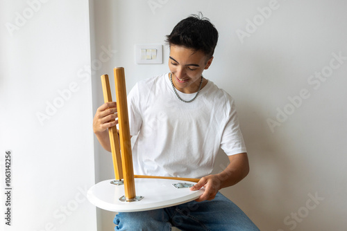 Trans man assembling furniture in new home photo