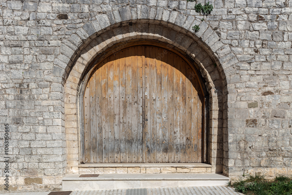 Fototapeta premium The background old beige stony wall with retro door