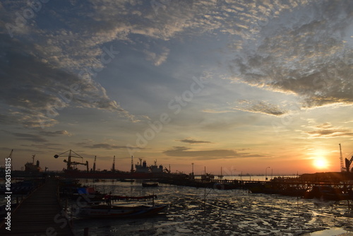 Landscape with fishing boats. dock at low tide in the morning with boats and wooden bridge. Fishing boats at the pier in the harbor at low tide. Dock scene at sunrise photo