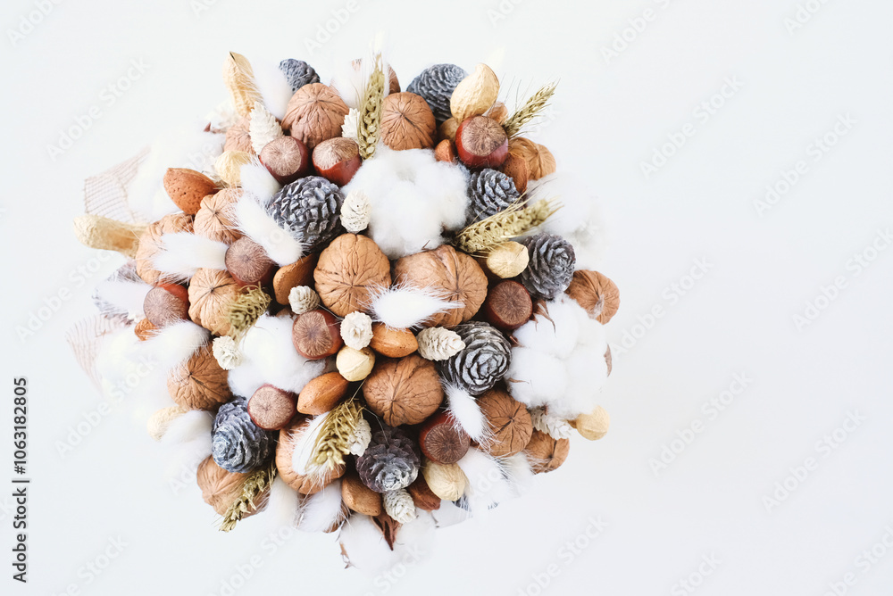 Beautiful handmade Christmas bouquet of nuts, pinecones and cotton flowers, top down view on white background. Holiday floral decor. Copy space for text. Beautiful handmade Christmas bouquet of nuts, pinecones and cotton flowers, top down view on white background. Holiday floral decor. Copy space for text.