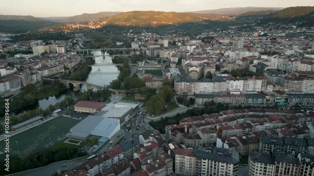 Drone shot of Ourense, Galicia, Spain, showcasing rooftops, river, and historic architecture at sunset with scenic landscape views Drone shot of Ourense, Galicia, Spain, showcasing rooftops, river, and historic architecture at sunset with scenic landscape views