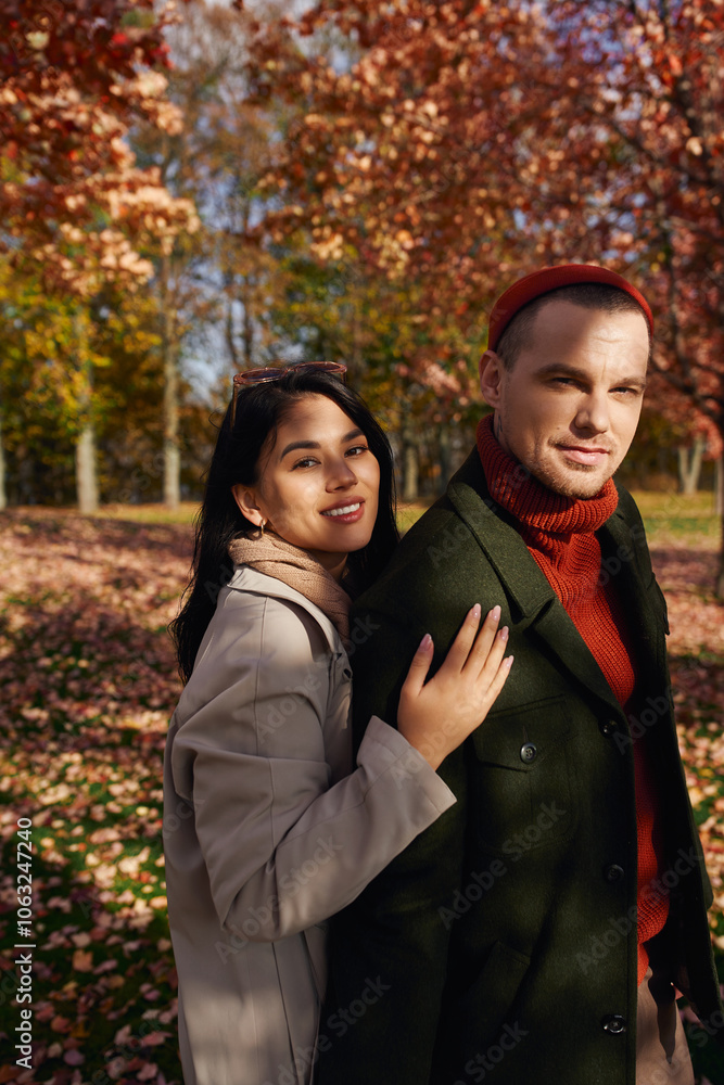 A loving couple in cozy autumn attire enjoys each others company amidst colorful leaves. A loving couple in cozy autumn attire enjoys each others company amidst colorful leaves.