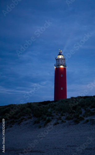 De Cocksdorp, Texel, The Netherlands, October 27th, 2024, Lighthouse standing tall at night, serving as a beacon of hope by the ocean, creating a serene atmosphere. photo