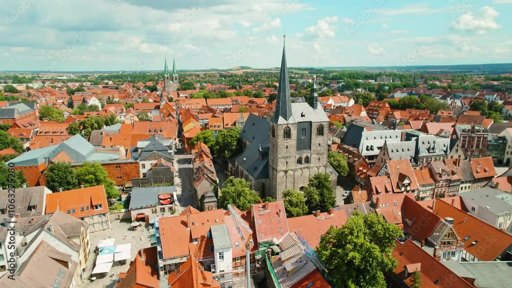 Historic European townscape with red-tiled roofs and medieval church spires under blue summer sky Historic European townscape with red-tiled roofs and medieval church spires under blue summer sky