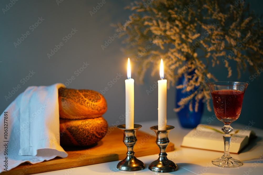 Shabbat or Sabbath kiddush ceremony composition with a traditional sweet fresh loaf of challah bread, glass of red kosher wine and candles on a vintage wood table with copy space Shabbat or Sabbath kiddush ceremony composition with a traditional sweet fresh loaf of challah bread, glass of red kosher wine and candles on a vintage wood table with copy space