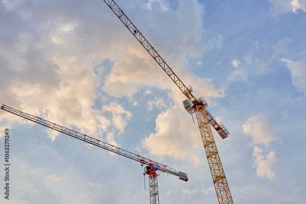 Construction cranes against blue sky. Construction of new housing and development of urban infrastructure Construction cranes against blue sky. Construction of new housing and development of urban infrastructure