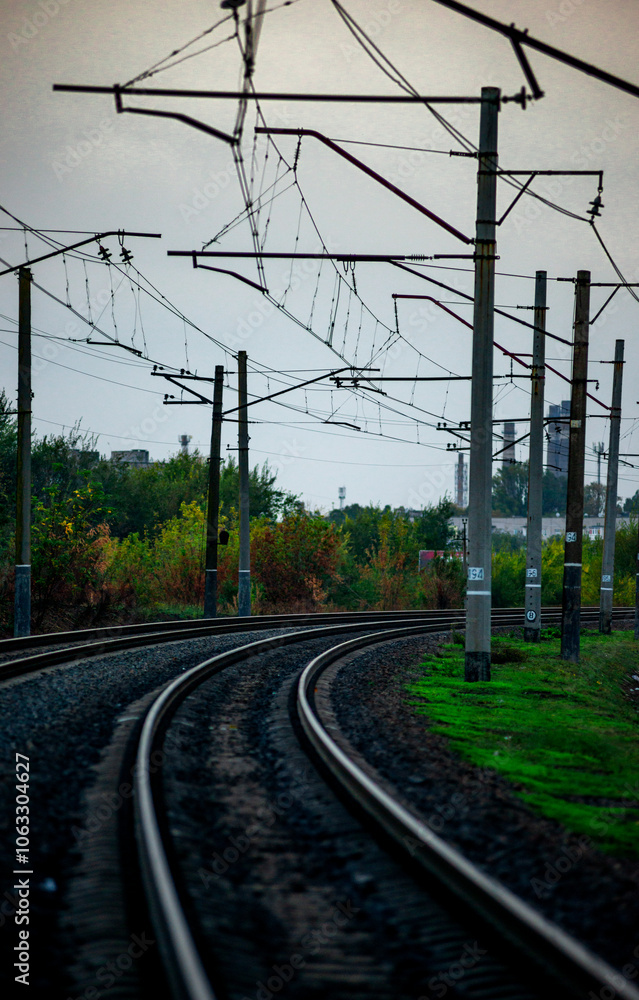 Railway road at autumn evening with autumn colors.Railroad near the forest with powerlines over the trees.Clouds in the sky,photography in the rainy weather .Landscape photo with train on the rails Railway road at autumn evening with autumn colors.Railroad near the forest with powerlines over the trees.Clouds in the sky,photography in the rainy weather .Landscape photo with train on the rails
