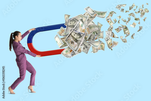 Valokuva Businesswoman attracting dollar bills with magnet on light blue background