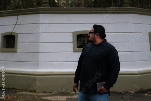 Man waiting in a park impatiently with a book in his hand photo