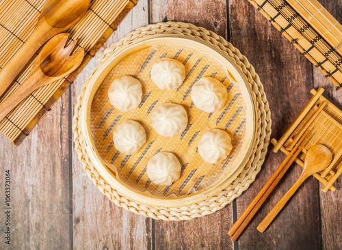 Wall Mural Steamed Shrimp soup dumplings with chopsticks and spoon served in bamboo steamer