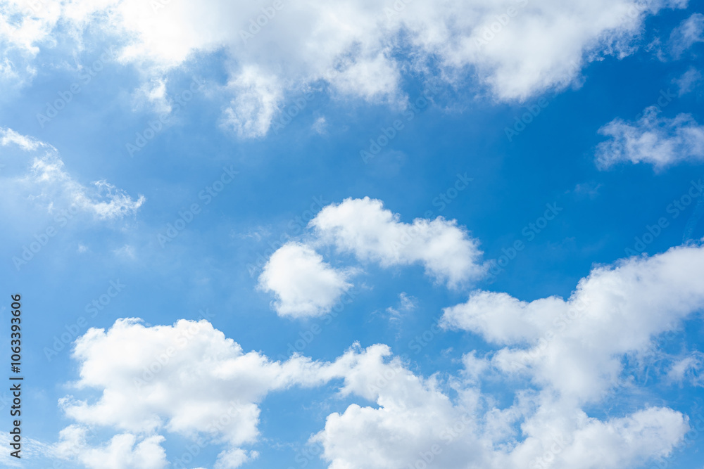 Fluffy cumulus clouds drift across a vibrant blue sky Fluffy cumulus clouds drift across a vibrant blue sky
