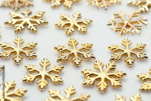 A collection of intricate golden snowflakes scattered across a clean white surface