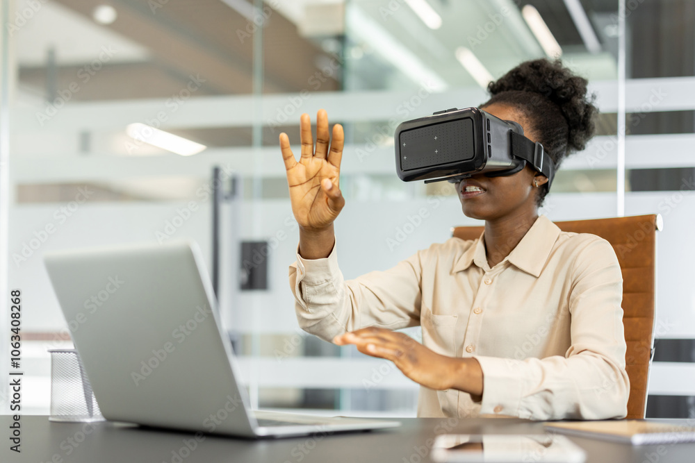 Young african american business woman using VR headset in modern office. Embracing technology, interacting with virtual reality, and exploring innovative solutions. Concept future work environments. Young african american business woman using VR headset in modern office. Embracing technology, interacting with virtual reality, and exploring innovative solutions. Concept future work environments.