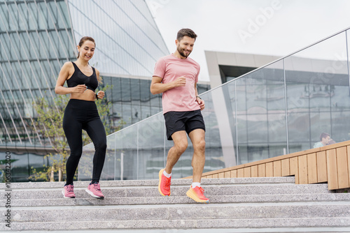 Two Joggers Running Down Steps in an Urban Setting During Daytime, Showcasing a Lively Fitness Routine