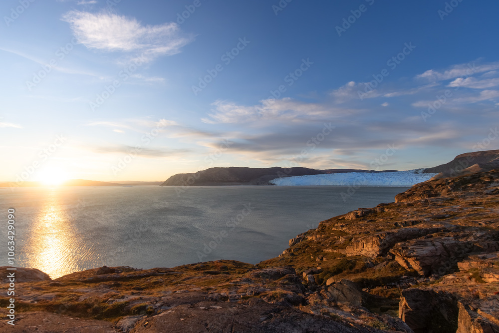 Panoramic view of bay at Eqi Glacier (Eqip Sermia) in Greenland north of Ilulissat during sunset with golden hour colours. Panoramic view of bay at Eqi Glacier (Eqip Sermia) in Greenland north of Ilulissat during sunset with golden hour colours.