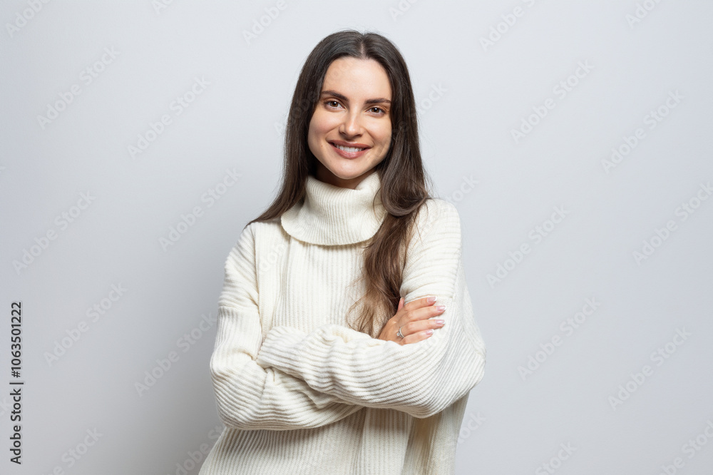 Portrait of a beautiful woman wearing a white sweater, on light gray background. Portrait of a beautiful woman wearing a white sweater, on light gray background.