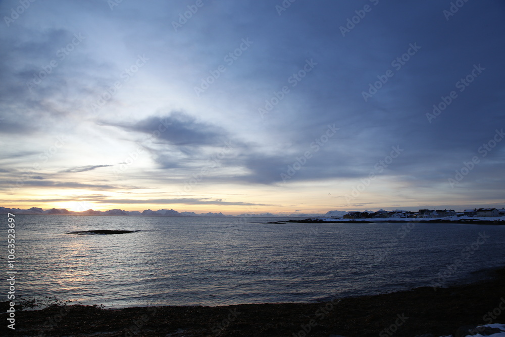 Obraz premium Alba sul villaggio di Andenes, a nord dell'isola di Andoya., con vista sull'isola di Senja. Isole Vesteralen, Norvegia del nord.