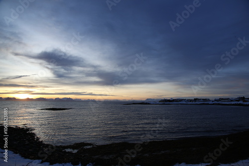 Alba sul villaggio di Andenes, a nord dell'isola di Andoya., con vista sull'isola di Senja. Isole Vesteralen, Norvegia del nord.