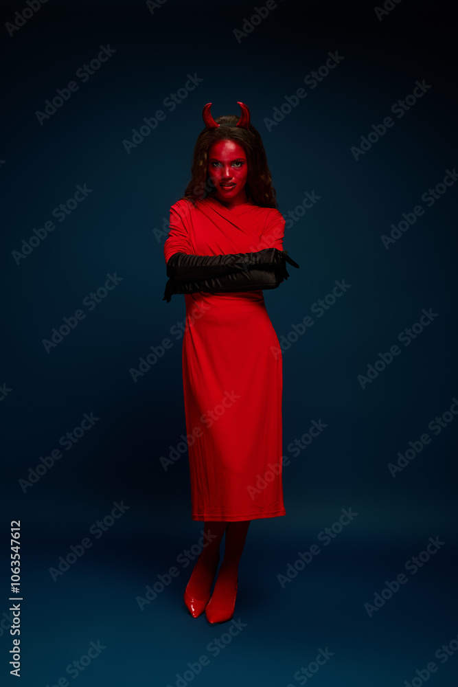 Dressed in a bold red devil costume, she embodies Halloween spirit with a fierce look. Dressed in a bold red devil costume, she embodies Halloween spirit with a fierce look.