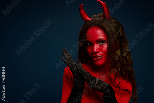 A captivating woman dressed in a striking Halloween outfit exudes confidence and allure.