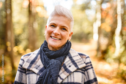 Mature woman in autumn forest, dressed in cozy fall attire, Reflection and connection with nature, wellness