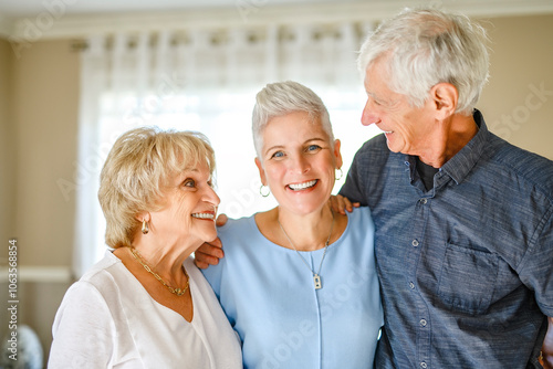 Happy daughter embracing her two elderly parents at living room. Love and care.