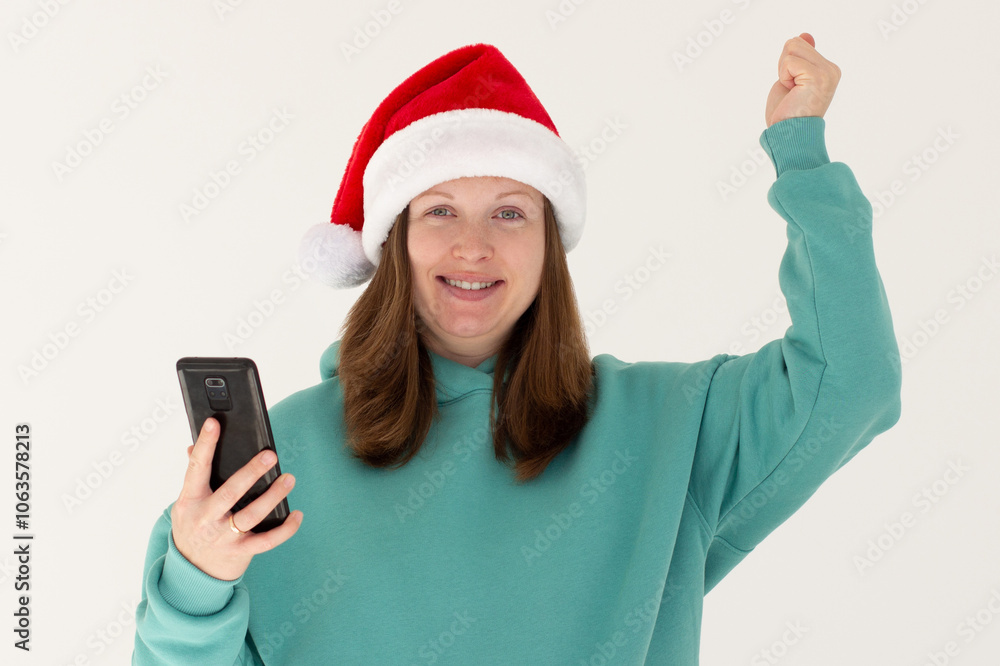 Photo portrait of cheerful woman celebrating victory holding phone in one hand fist in air isolated on white background Photo portrait of cheerful woman celebrating victory holding phone in one hand fist in air isolated on white background